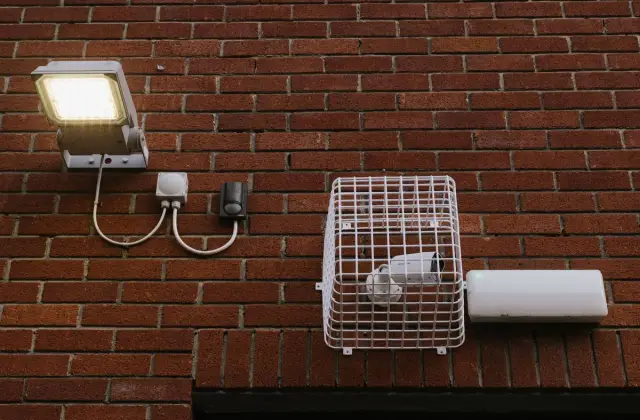 Brick wall exterior with a security camera and LED light installed