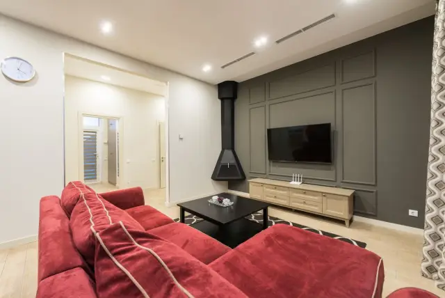 Modern living room with a wall-mounted TV and integrated home technology