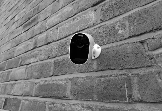 Security camera mounted on a brick wall exterior of a home