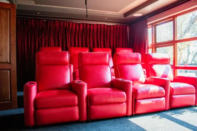 Home theatre room with a large screen and reclining seating in a residential setting